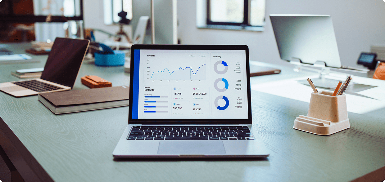 Laptop displaying graphs and charts on desk.